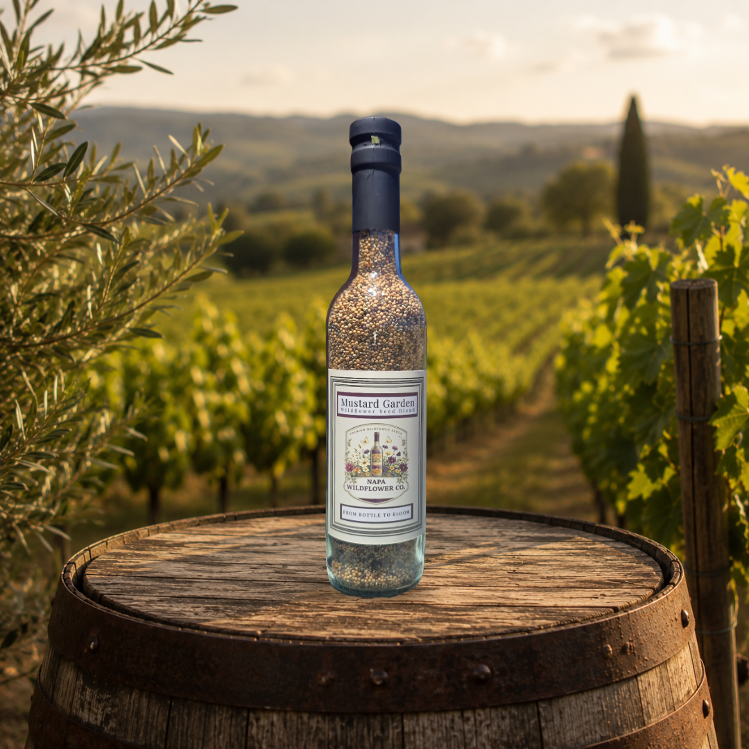 A bottle of Mustard Garden Wildflower Cover Crop Seed placed on the edge of a wooden barrel, with a blurred vineyard landscape in the background.