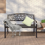 Decorative metal bench with 'WELCOME' text on a wooden deck against a white brick wall.