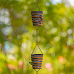 Decorative hanging planters with a rustic design against a blurred green background