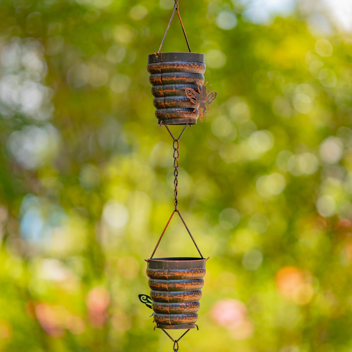 Decorative hanging planters with a rustic design against a blurred green background