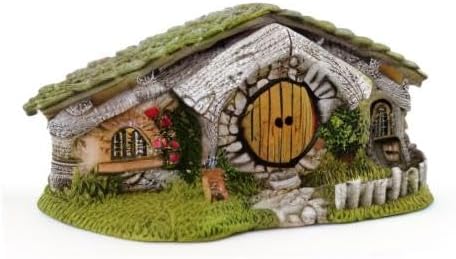Miniature fairy house with stone facade and round door on a white background
