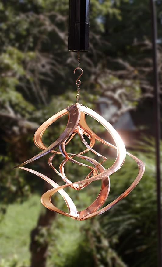 Decorative metal wind chime hanging against a blurred natural background