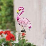 Pink flamingo-shaped rain gauge with a blurred garden background