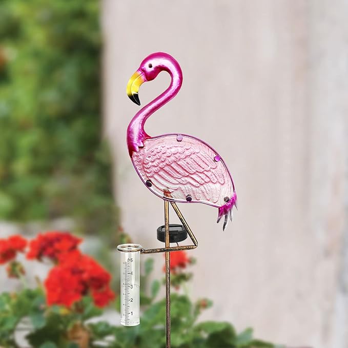 Pink flamingo-shaped rain gauge with a blurred garden background