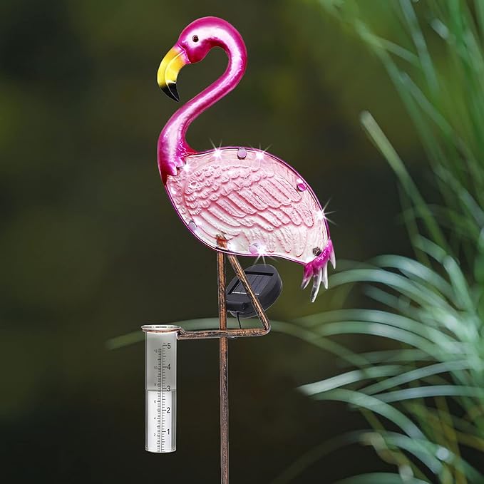 Pink flamingo garden stake with a ruler for scale against a green plant background