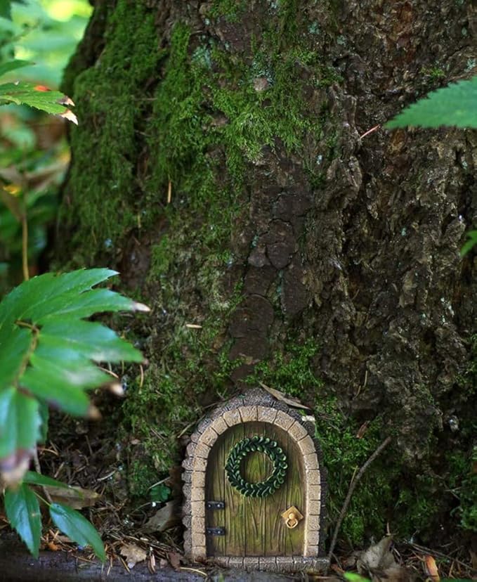 Small fairy door embedded in a tree trunk with greenery around