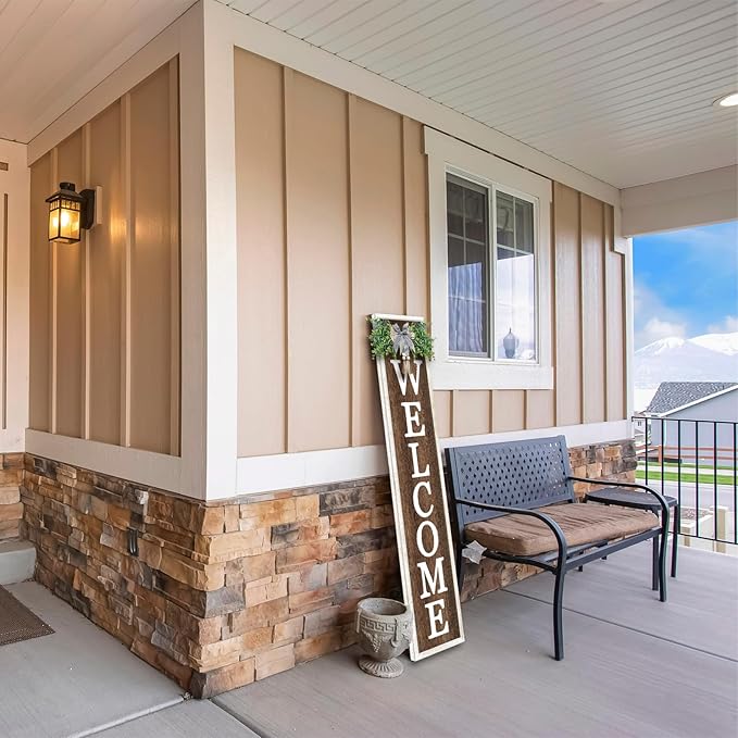 Front porch with a 'Welcome' sign, bench, and decorative elements.
