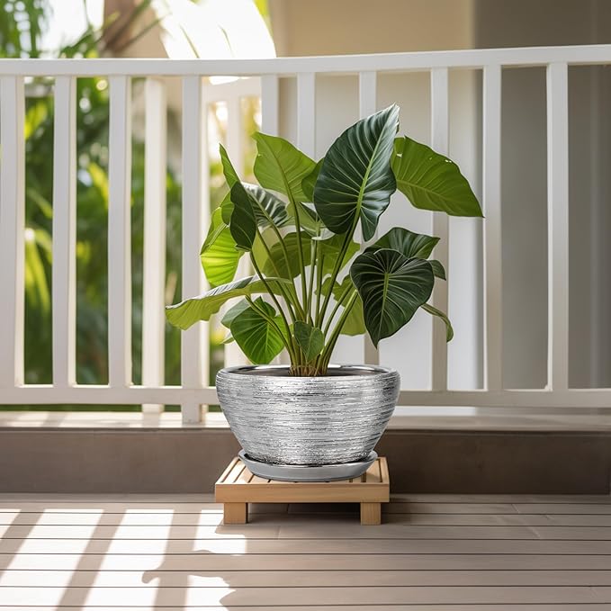 Potted plant on a wooden stand with a white railing and greenery in the background