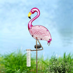 Pink flamingo-shaped garden stake with rain gauge against a blue sky and green grass background