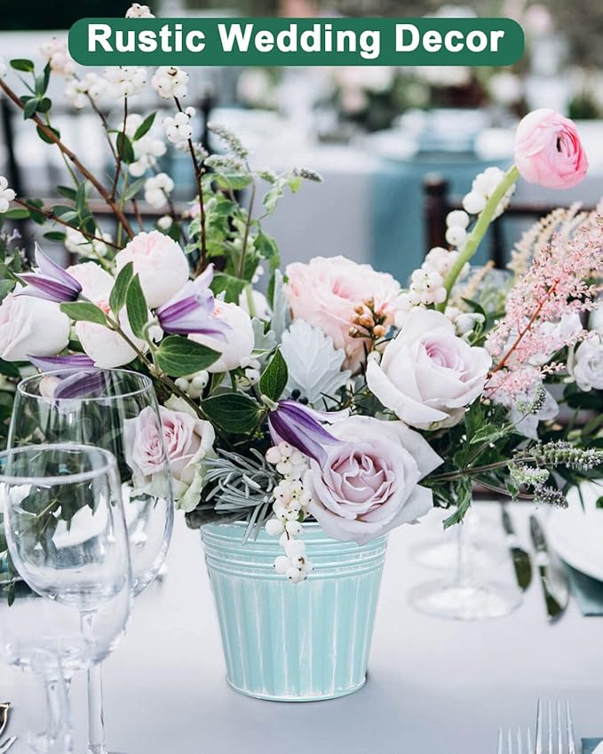 Rustic wedding decor with floral arrangement in a blue bucket on a table.