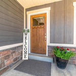 Front door of a house with a 'Welcome' sign and potted plant