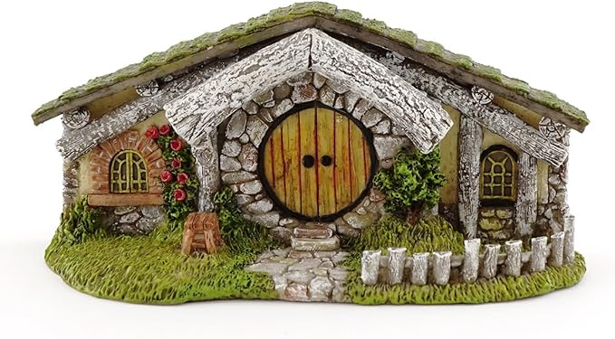 Miniature stone cottage with a round door on a white background