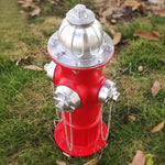 Red fire hydrant with silver top on grass