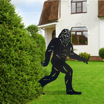 Black silhouette of a creature on a grassy lawn in front of a house
