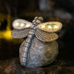 Decorative stone dragonfly with solar lights on a natural background