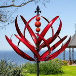 Red metal garden sculpture with a blue sky and ocean background