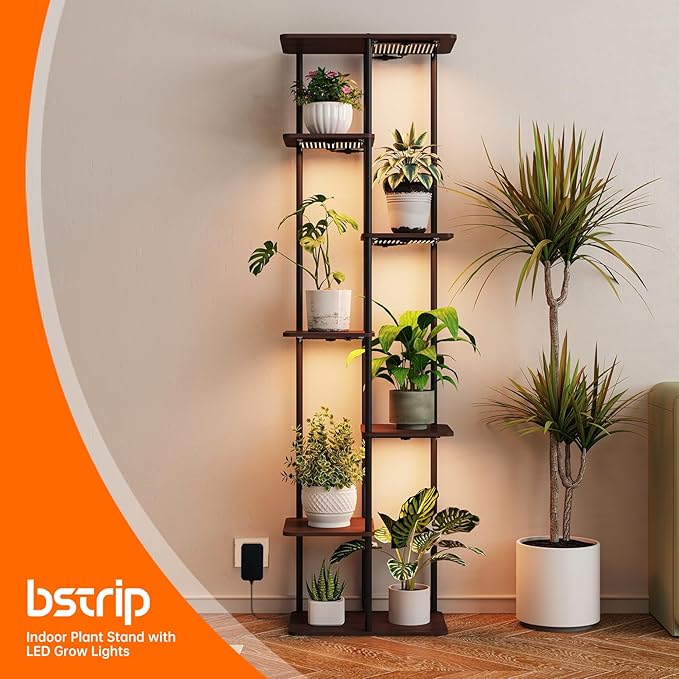 Indoor plant stand with LED grow lights displaying various potted plants against a neutral wall.