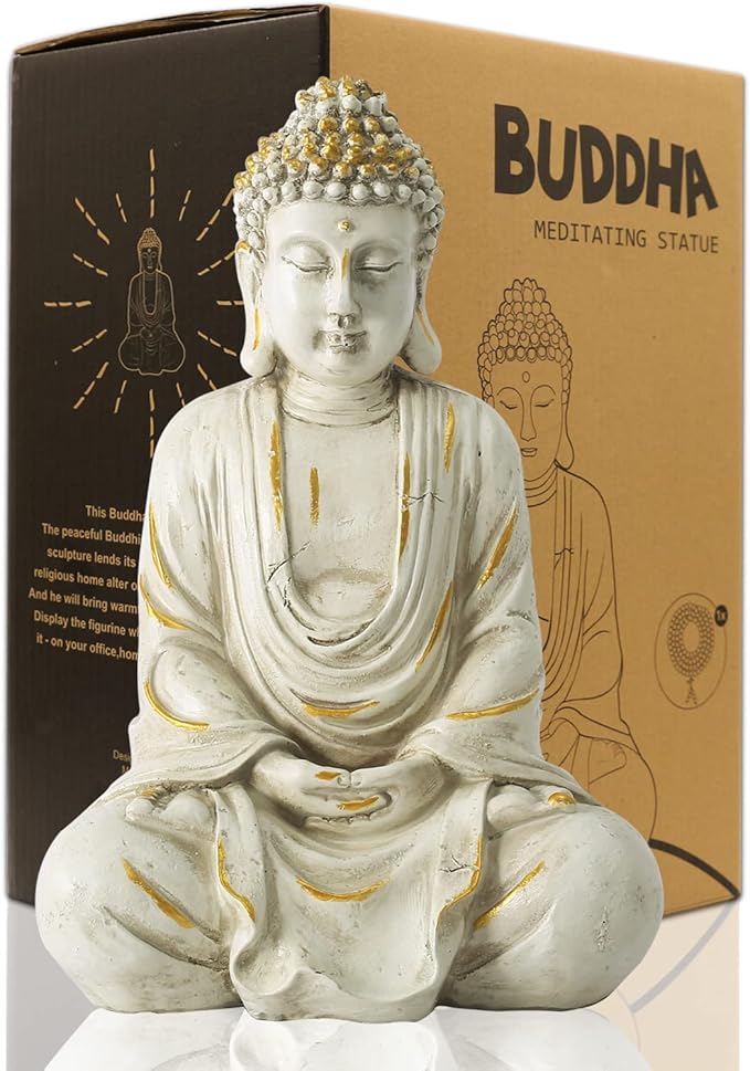 Buddha meditating statue with gold accents on a white surface, against a brown box with Buddha illustration.