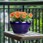 Blue pot with orange flowers on a wooden table outdoors
