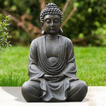 Statue of a meditating Buddha in a garden setting