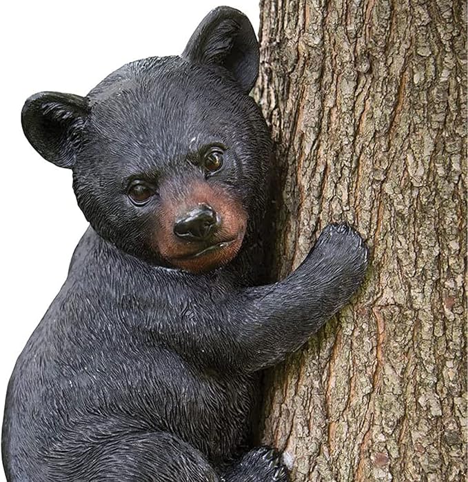 Statue of a bear cub climbing a tree on a white background