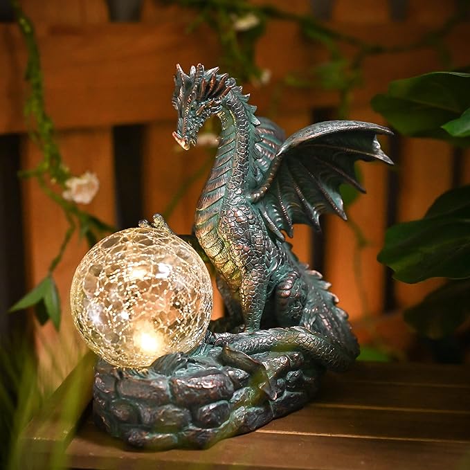 Dragon-shaped solar light with a glowing ball on a wooden surface