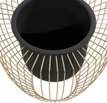 Black pot on a gold wire stand against a white background