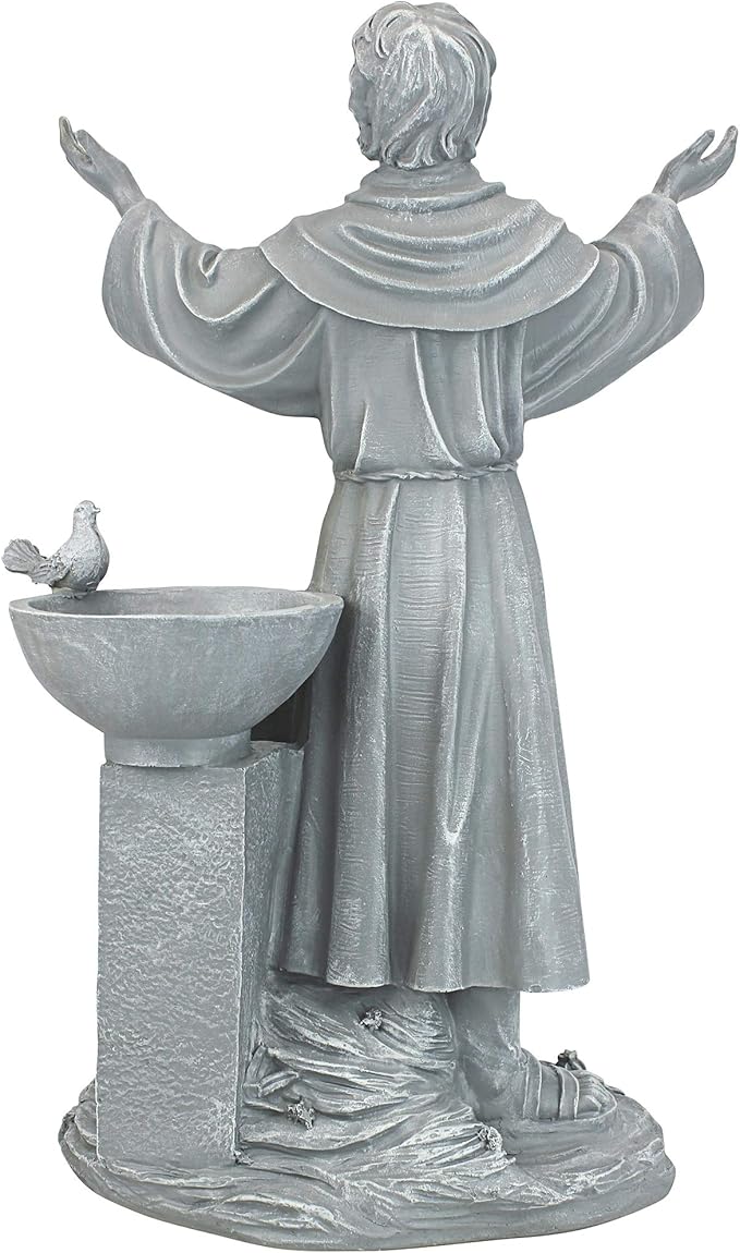 Statue of a religious figure with outstretched arms next to a bird bath on a white background