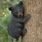 Black bear cub climbing a tree in a forest setting
