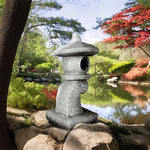 Stone lantern in a garden setting with a pond and trees