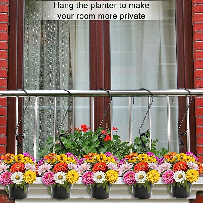 Hanging planters with colorful flowers on a railing next to a window.