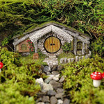Miniature stone cottage with a round door in a forest setting