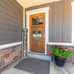 Front door of a house with a 'Welcome' sign and potted plants.