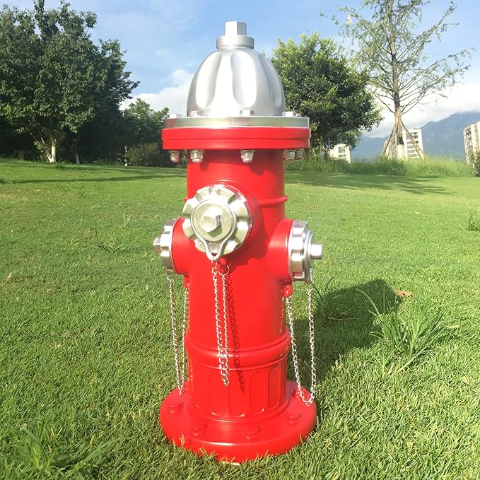 Red fire hydrant with silver components on a grassy area