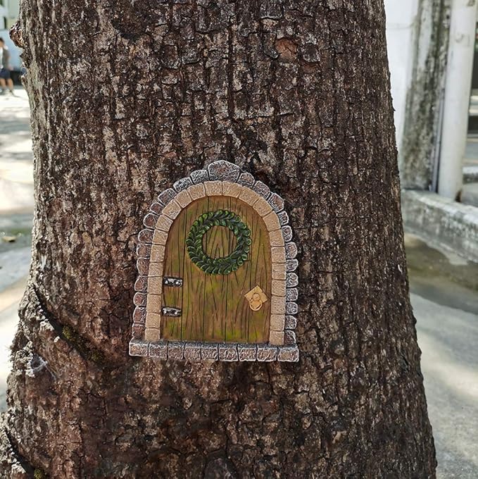Fairy door with a wreath attached to a tree trunk