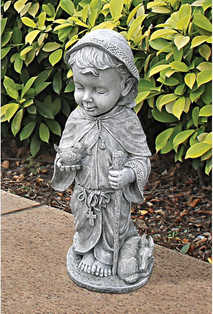 Statue of a child in a garden setting with green foliage.