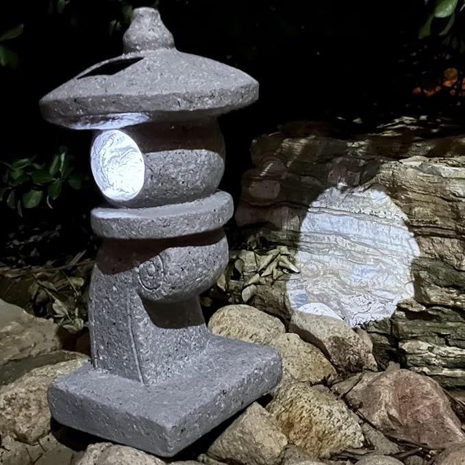 Stone lantern-style light fixture on a rocky surface with a dark background