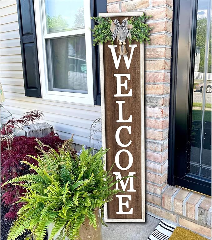 Wooden 'WELCOME' sign with decorative elements on a house exterior.