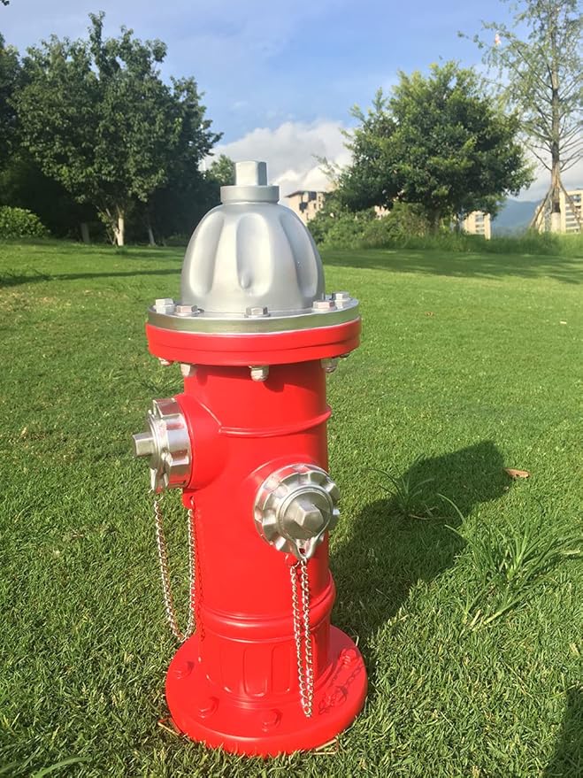 Red fire hydrant with silver components on a grassy area