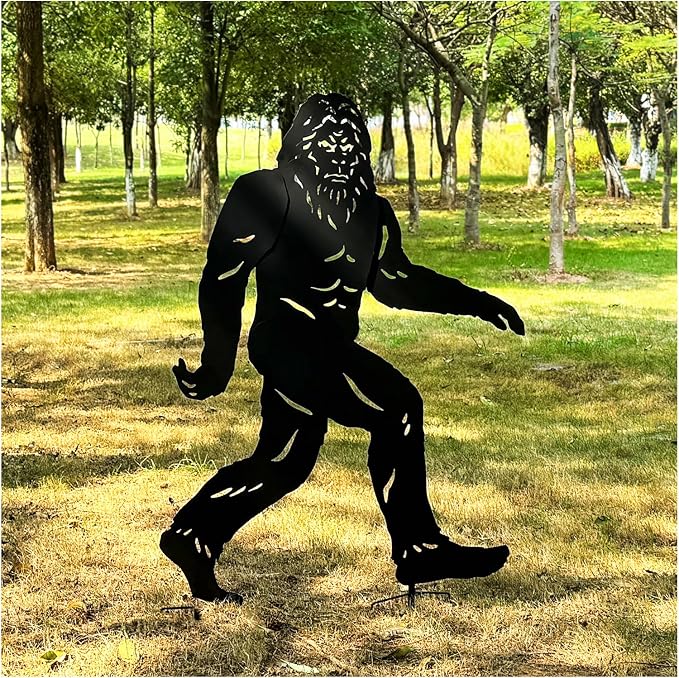 Black metal sculpture of a creature in a park setting