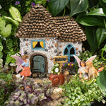 Miniature fairy house with fairies and a dog in a garden setting