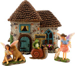 Fairy garden set with a small house, fairies, and animals on a white background