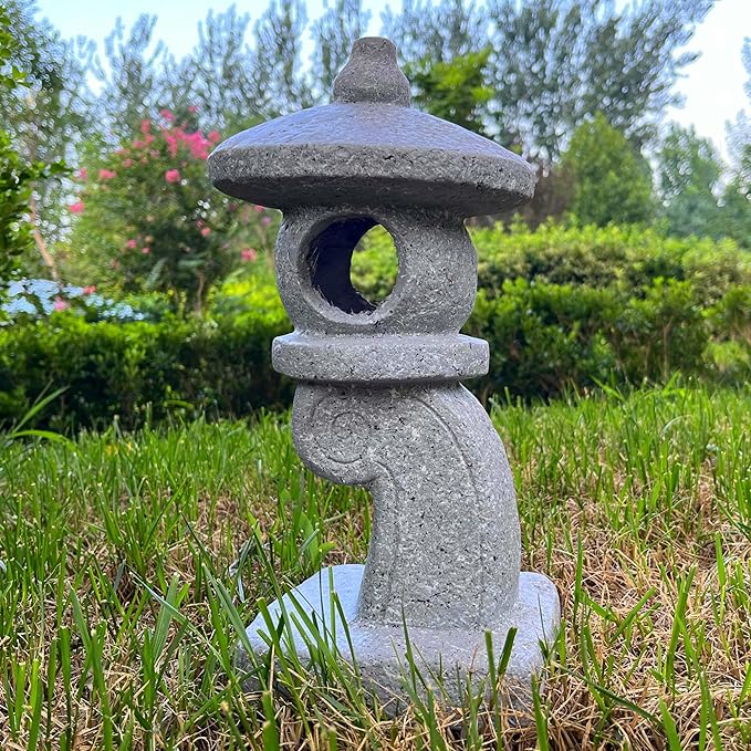 Stone lantern in a garden setting with greenery in the background