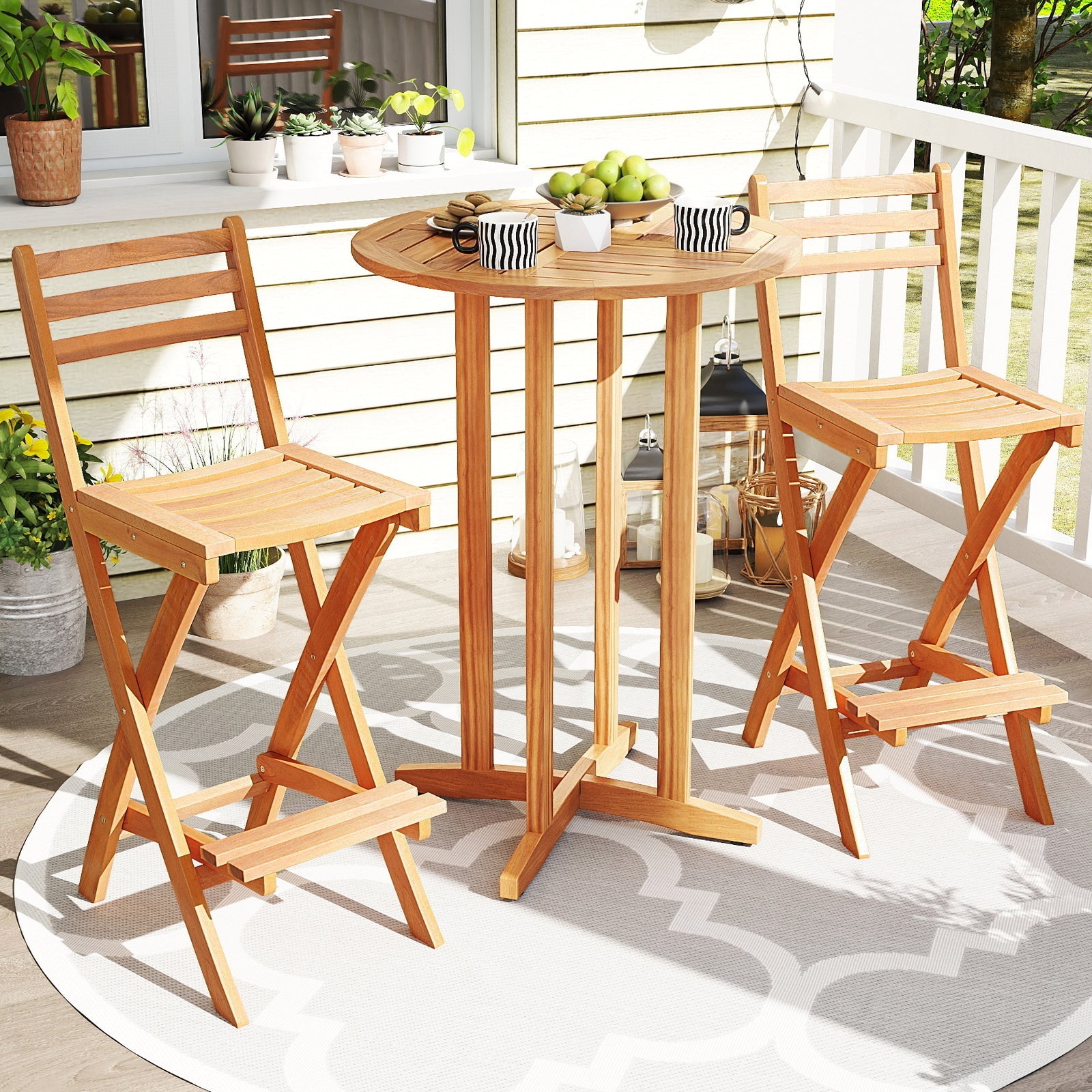 Wooden outdoor table and chairs on a patio with plants and a rug.