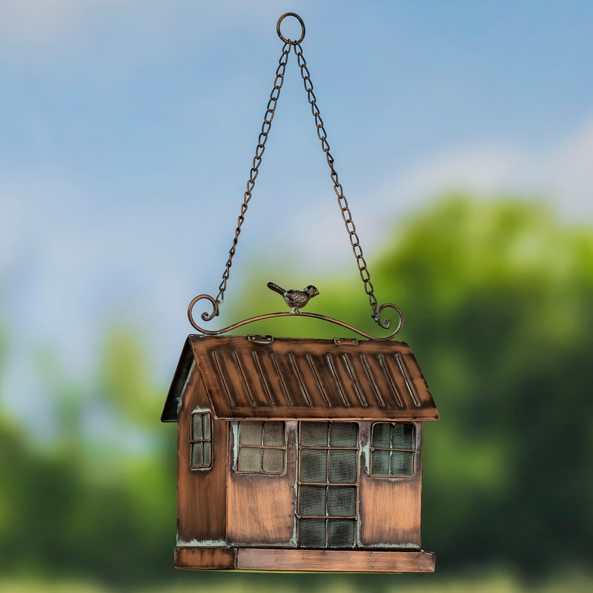 Decorative birdhouse hanging against a blurred natural background
