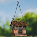 Decorative birdhouse hanging against a blurred natural background