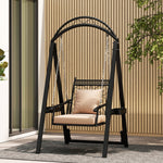Black metal swing with beige cushion on a patio