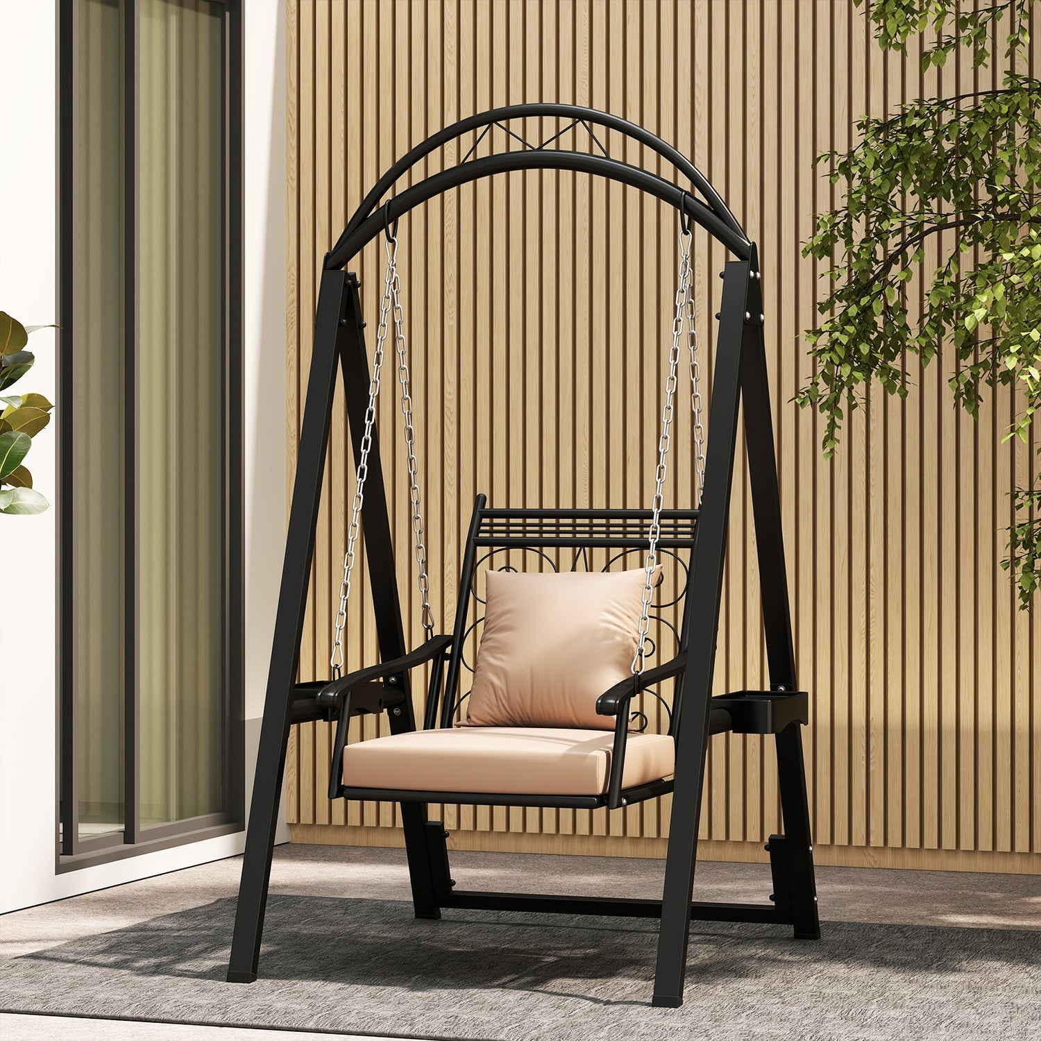 Black metal swing with beige cushion on a patio