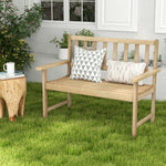 Wooden bench with decorative pillows on a grassy area, with a cup and plant nearby.