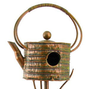 Decorative teapot birdhouse with a rustic metal finish on a white background